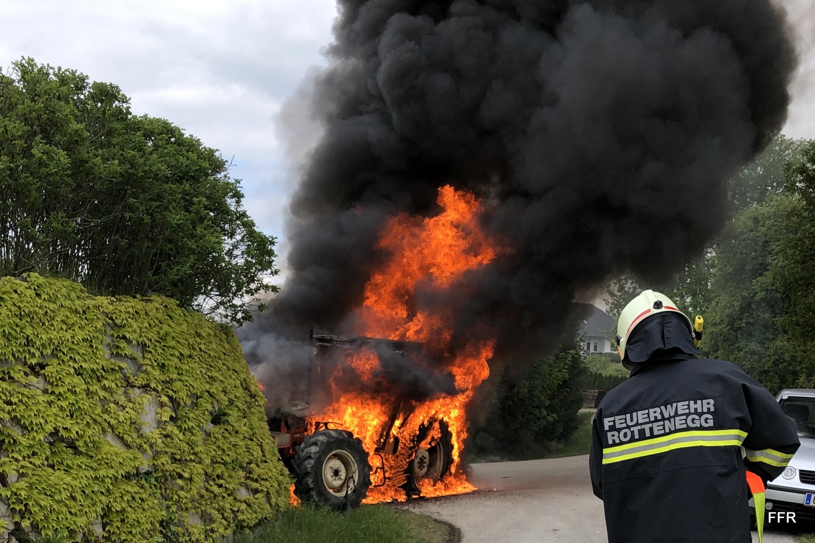 Feuerwehrmann vor brennendem Traktor